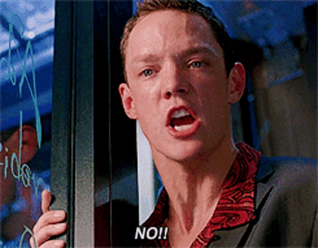 a man in a suit is making a funny face and says no