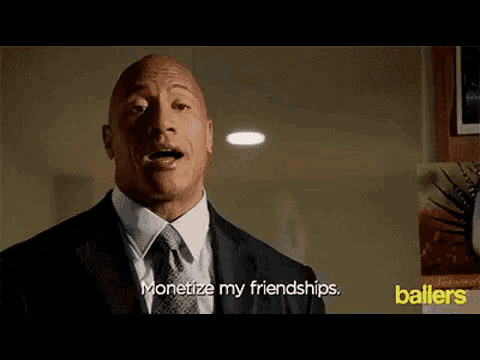 a bald man in a suit and tie is talking about monetizing his friendships