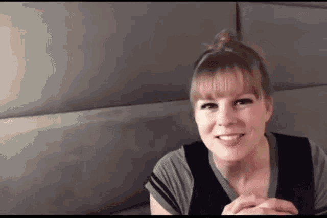 a woman is sitting on a couch and smiling .