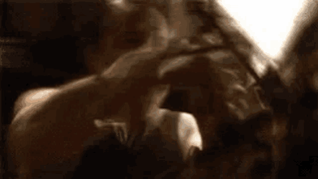a man is holding a woman 's head in a dark room .