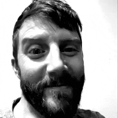 a man with a beard is smiling for the camera