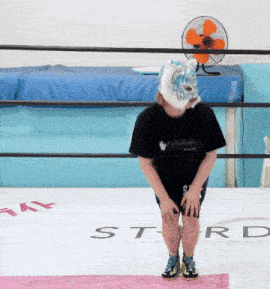 a person wearing a mask sits on a mat with the word star written on it