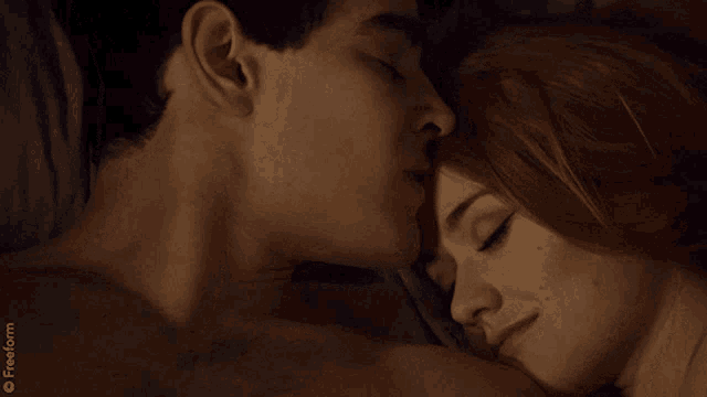 a man kissing a woman on the forehead with a freeform logo in the background