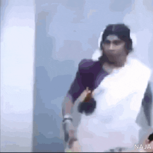 a blurred image of a woman wearing headphones and a saree .