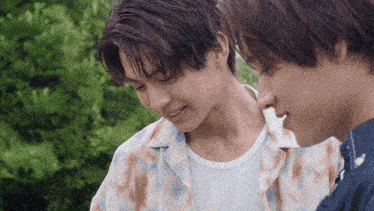 two young men are standing next to each other and one is smiling