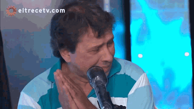 a man crying in front of a microphone with eltrecetv.com on the bottom