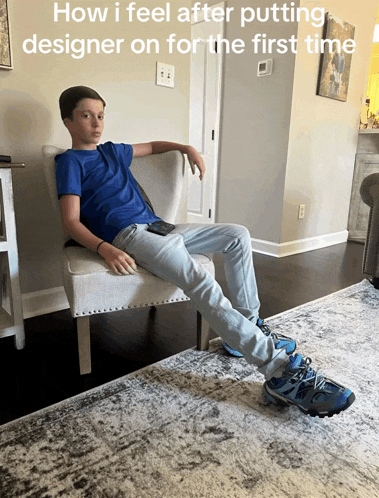 a boy sits in a chair with his legs crossed and a caption that says how i feel after putting designer on