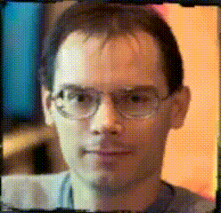 a close up of a man 's face with glasses in a pixelated image
