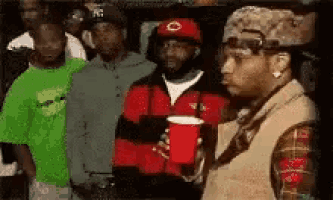 a group of men standing next to each other holding red cups .