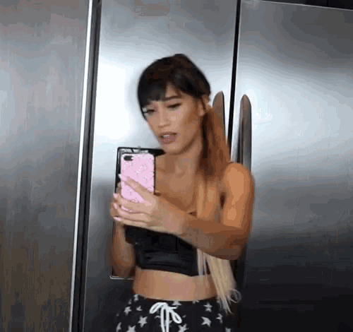 a woman is taking a picture of herself with a cell phone