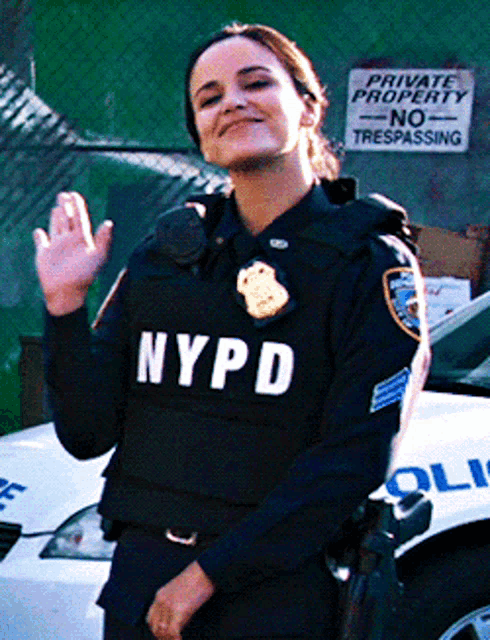 a woman in a nypd uniform is standing in front of a car