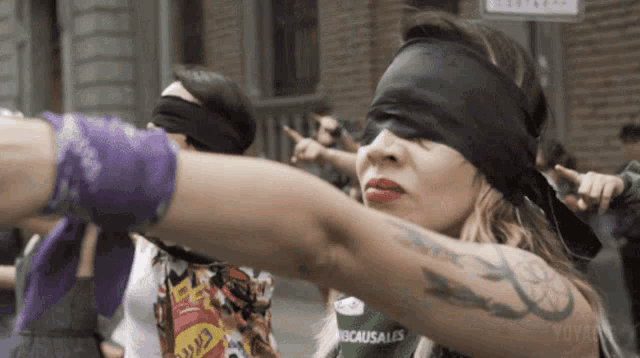 a woman wearing a blindfold has a tattoo on her arm that says yovanna