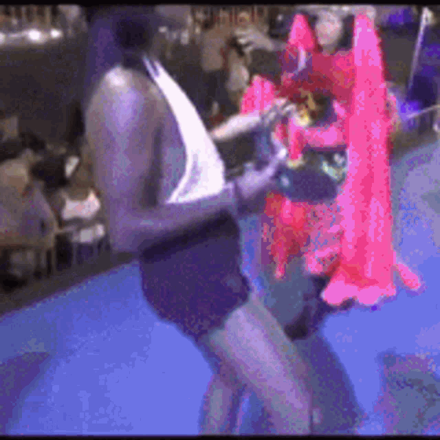 a woman in a pink dress is dancing with a man