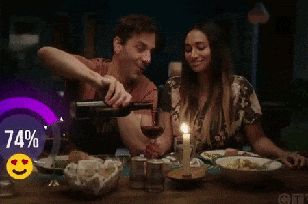 a man is pouring wine into a glass while a woman watches .