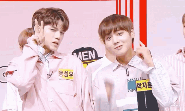 a group of young men are standing next to each other and one of them is wearing a pink shirt with the word men on it