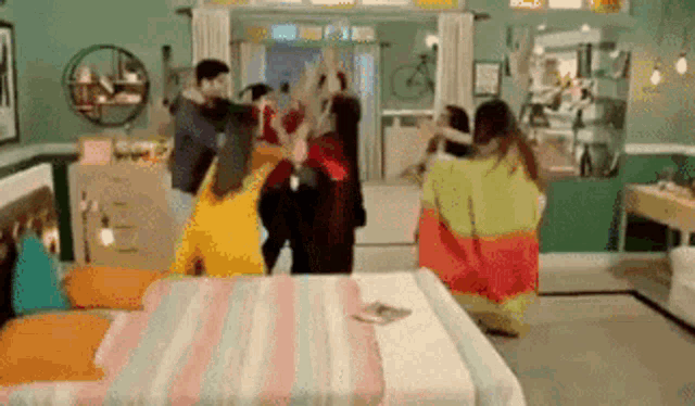 a group of people are standing around a bed in a room .