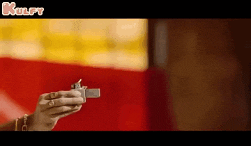 a person is holding a lighter in their hand in a blurry photo .