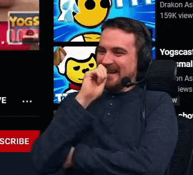 a man wearing headphones is sitting in front of a screen that says yogs