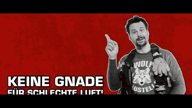 a man wearing a wolf shirt is pointing upwards