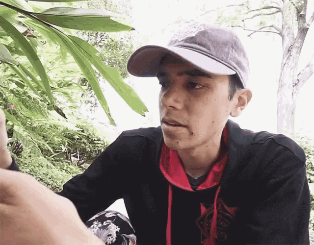 a young man wearing a hat and a hoodie that says ' ninjas ' on it