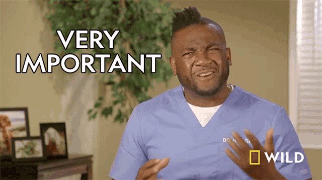 a man in a blue scrub is making a very important gesture