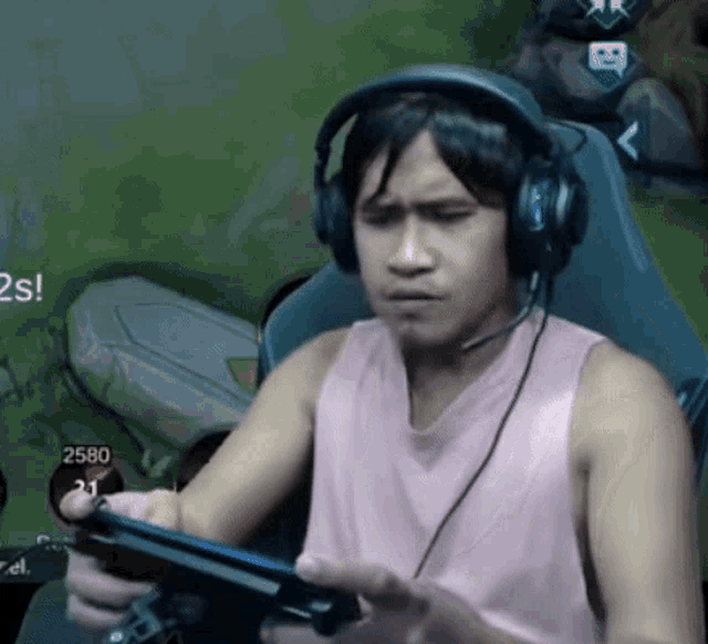 a man wearing headphones is playing a video game on a tablet .