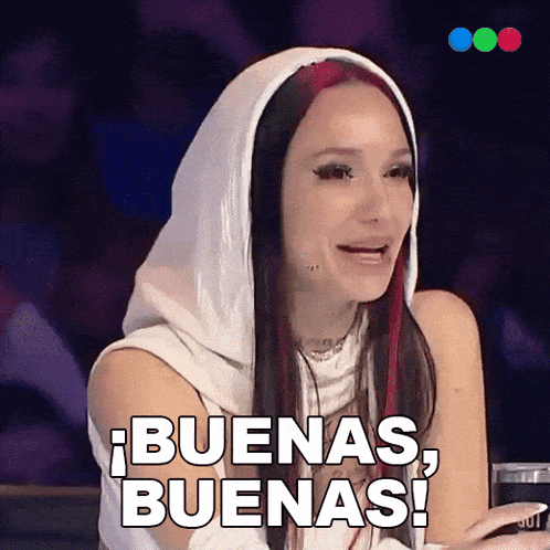 a woman with red hair is wearing a white hood and says buenas buenas !