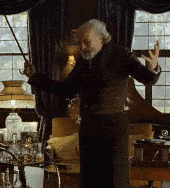 a man with a beard is holding a sword in a room