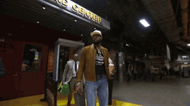 a man is walking in front of a building that says grand center