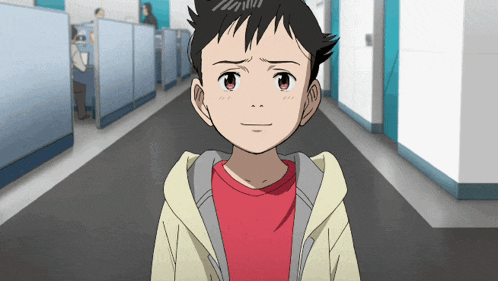 a young boy in a red shirt is standing in a hallway looking at the camera
