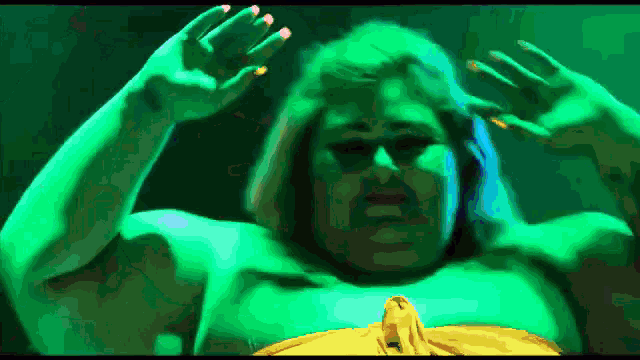 a pixelated image of a man in a green shirt with his hands outstretched