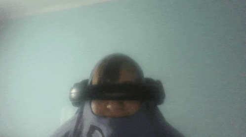 a person wearing headphones and a purple shirt with the letter c on the front