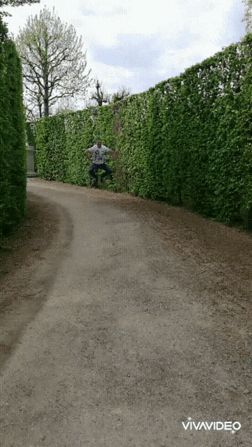 a man is jumping in the air on a dirt road with the words vivavideo below him