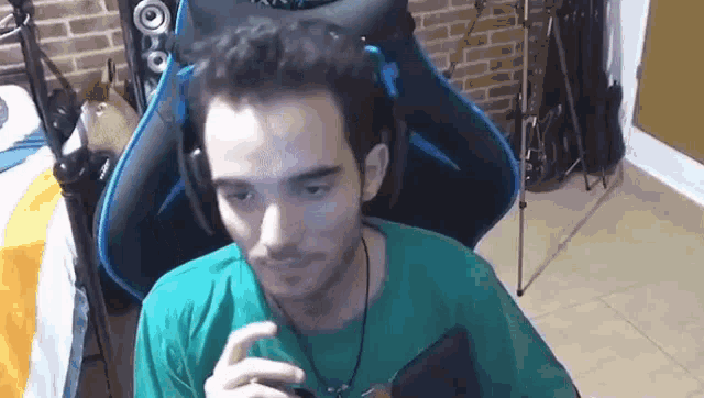 a man is sitting in a chair wearing headphones and looking at the camera .