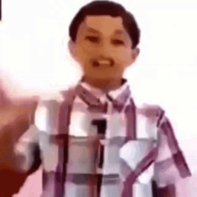 a young boy wearing a plaid shirt is standing in front of a microphone and smiling .