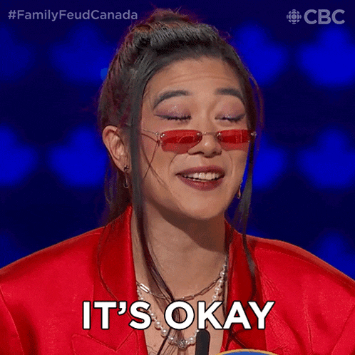 a woman wearing red sunglasses and a red jacket is smiling and saying it 's okay