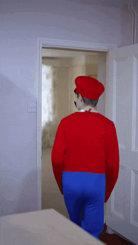 a man in a mario costume is walking into a room