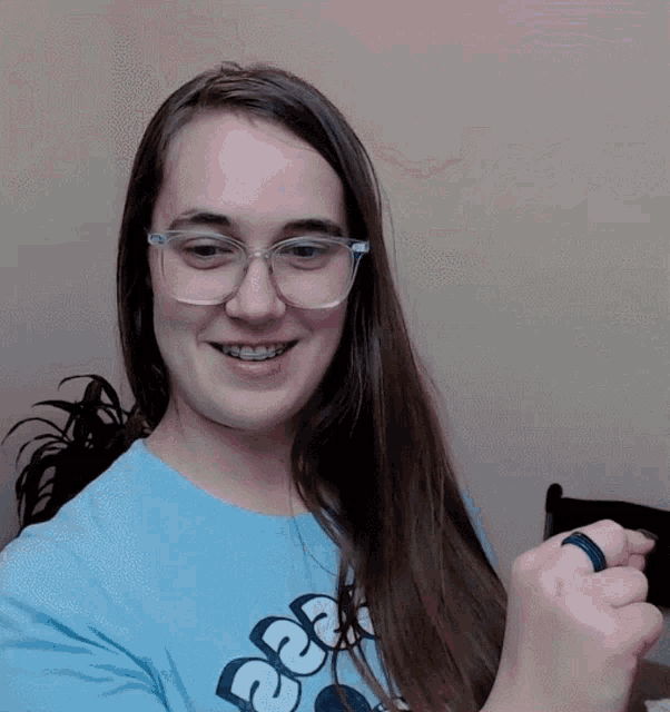 a woman wearing glasses and a blue shirt with the letters sdc on it