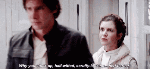 a man and a woman are standing next to each other in a room and the woman is talking to the man .