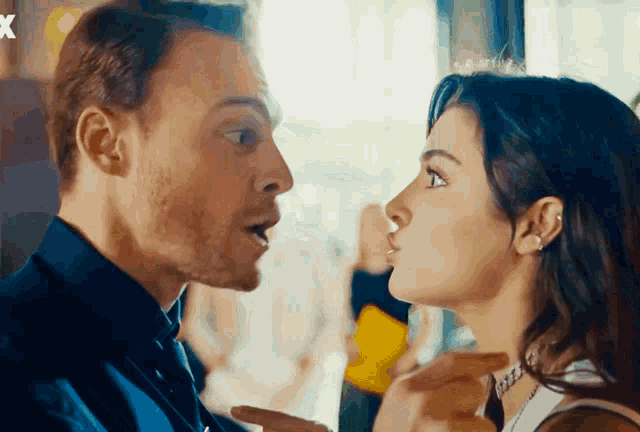 a man and a woman are looking at each other with the letter x in the corner