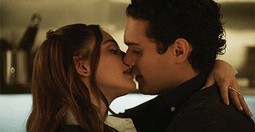 a man and a woman are kissing and the woman is wearing a ring