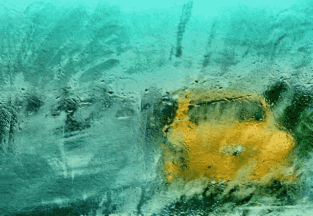 a yellow car is reflected in a window with a blue background