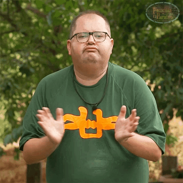 a man wearing glasses and a green shirt with the word paradise on the front
