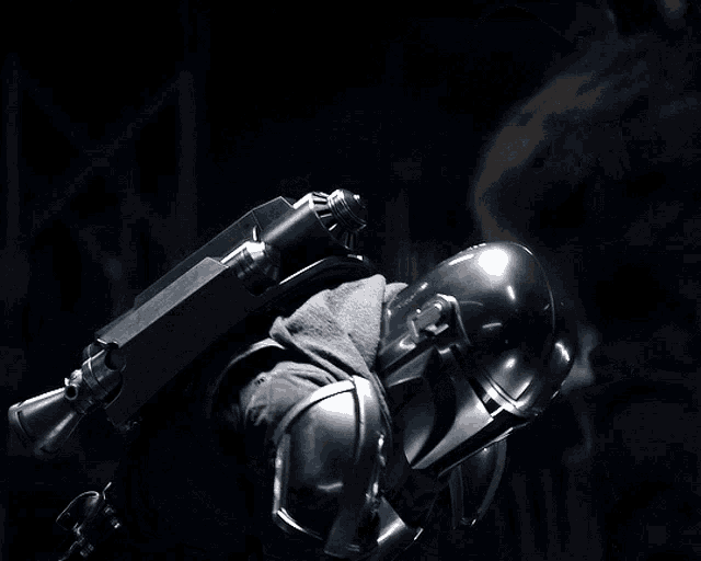 a close up of a person wearing a helmet with a gun on the back