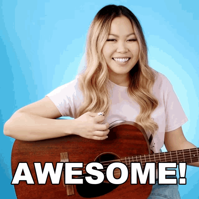 a woman is holding a guitar with the words awesome written on it