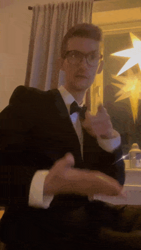 a man in a tuxedo and bow tie is dancing