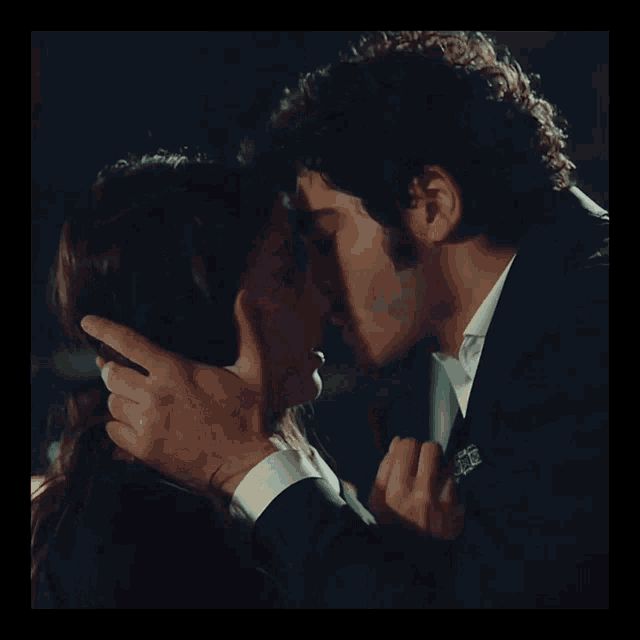 a man and a woman are kissing and the man is wearing a watch