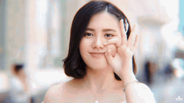 a woman making an ok sign with her hand