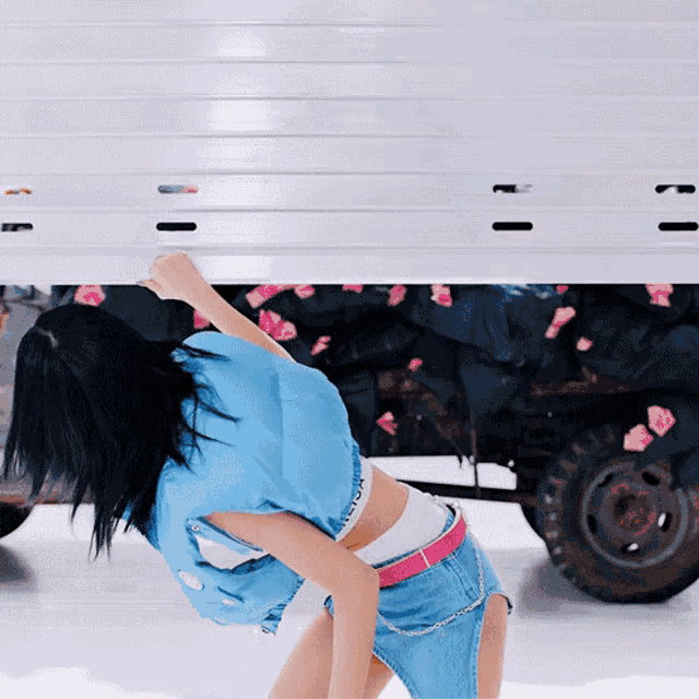 a woman in a blue shirt with the word calvin klein on it stands in front of a white truck