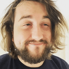 a man with a beard and long hair is smiling